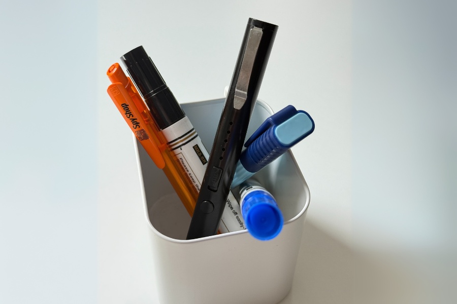 Paralizator TW-1903 w kubku na przybory, pomieszany z flamastrami, długopisem i mazakami.