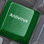 Na grafice zielony klawisz na klawiaturze z napisem „Antivirus” – symbol ochrony. Ranking TOP 5 antywirusów 2025