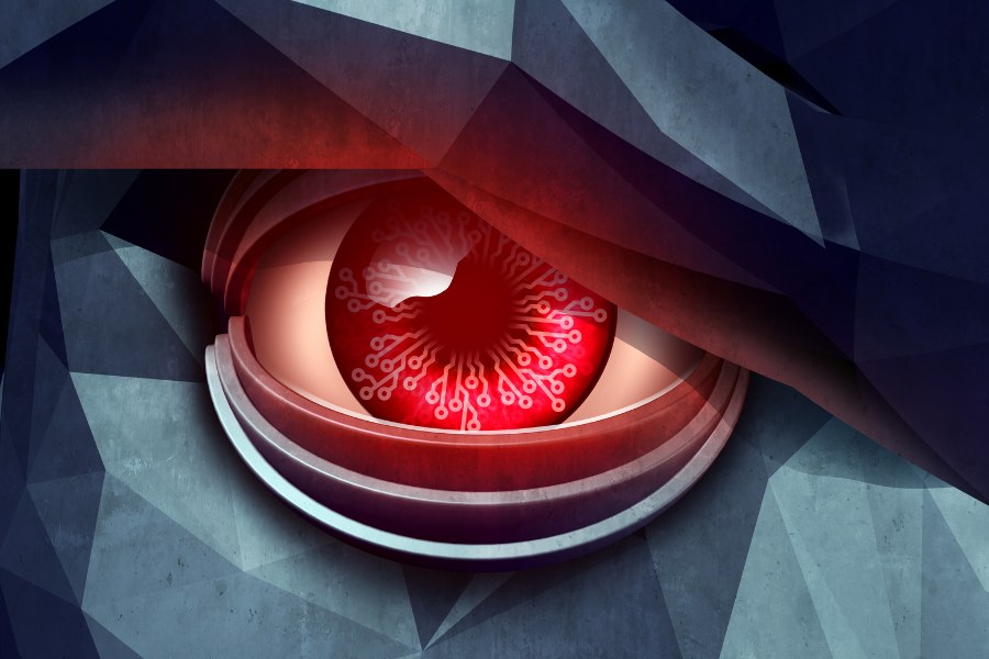 Zbliżenie na czerwone, cybernetyczne oko ukryte pod ciemną, dużą brwią. Technologiczna siatkówka przypomina obwody elektroniczne.