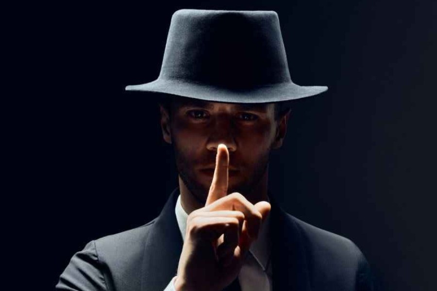 Detektyw z palcem na ustach – zachowanie ciszy na miejscu zbrodni.