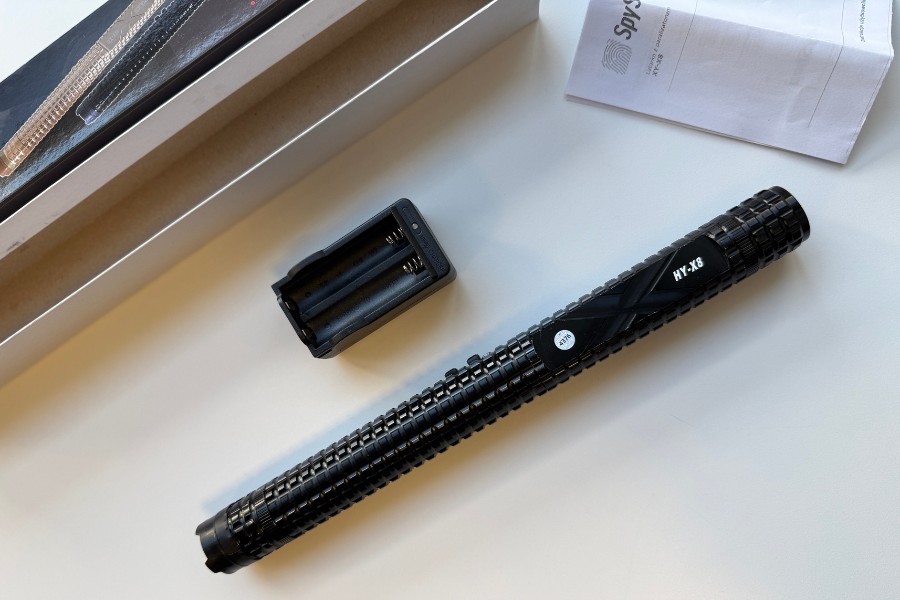 Paralyseur X8 i akumulator do ładowania baterii na białym stole. W tle instrukcja obsługi i opakowanie.