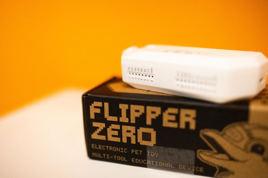 Flipper Zero leży na ciemnym oryginalnym pudełku.
