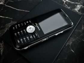Telefon Tripleton Enigma E2 leży na czarnym pudełku na marmurowym blacie.