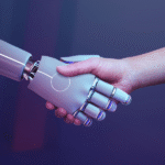 Ludzka dłoń ściska dłoń humanoidalnego robota na ciemnym, fioletowo-niebieskim tle.