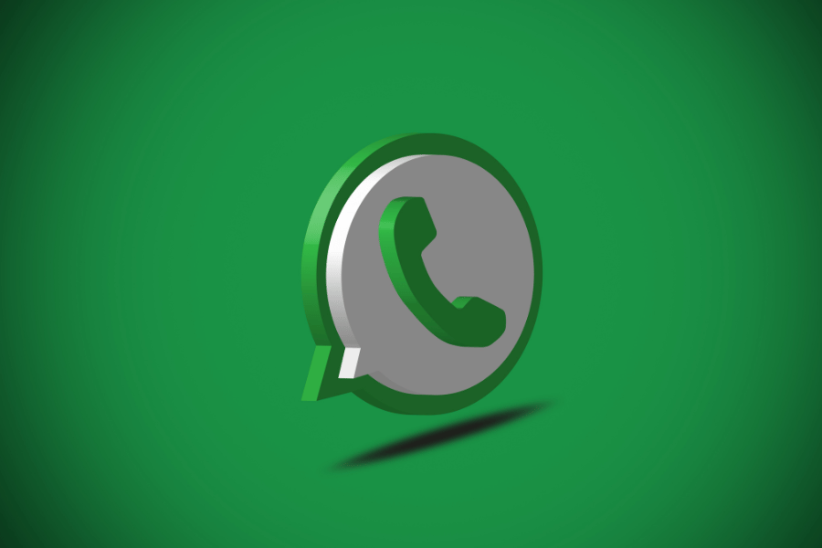 Duże biało-zielone logo komunikatora Whatsapp. W tle znajduje się jasne, zielone tło z przyciemnionymi narożnikami.