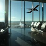 Terminal lotniska z samolotem za przeszkloną ścianą, ilustracja zabezpieczeń i kontroli bezpieczeństwa na lotnisku.