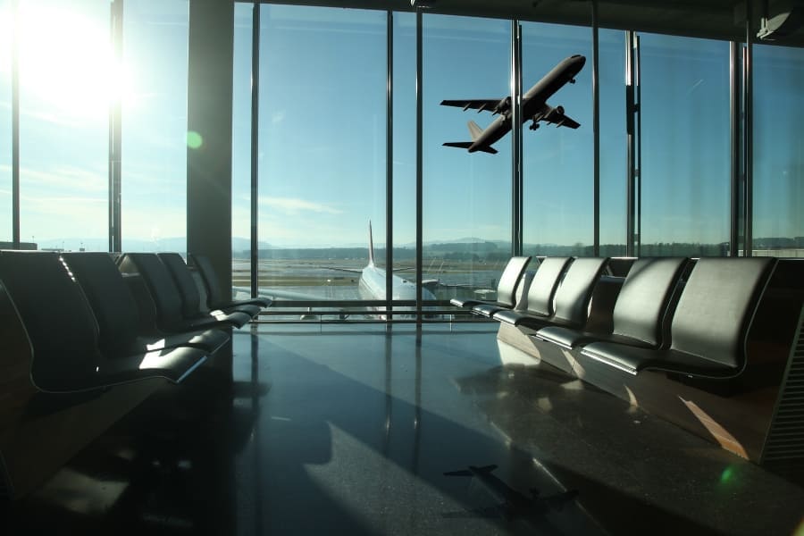Terminal lotniska z samolotem za przeszkloną ścianą, ilustracja zabezpieczeń i kontroli bezpieczeństwa na lotnisku.